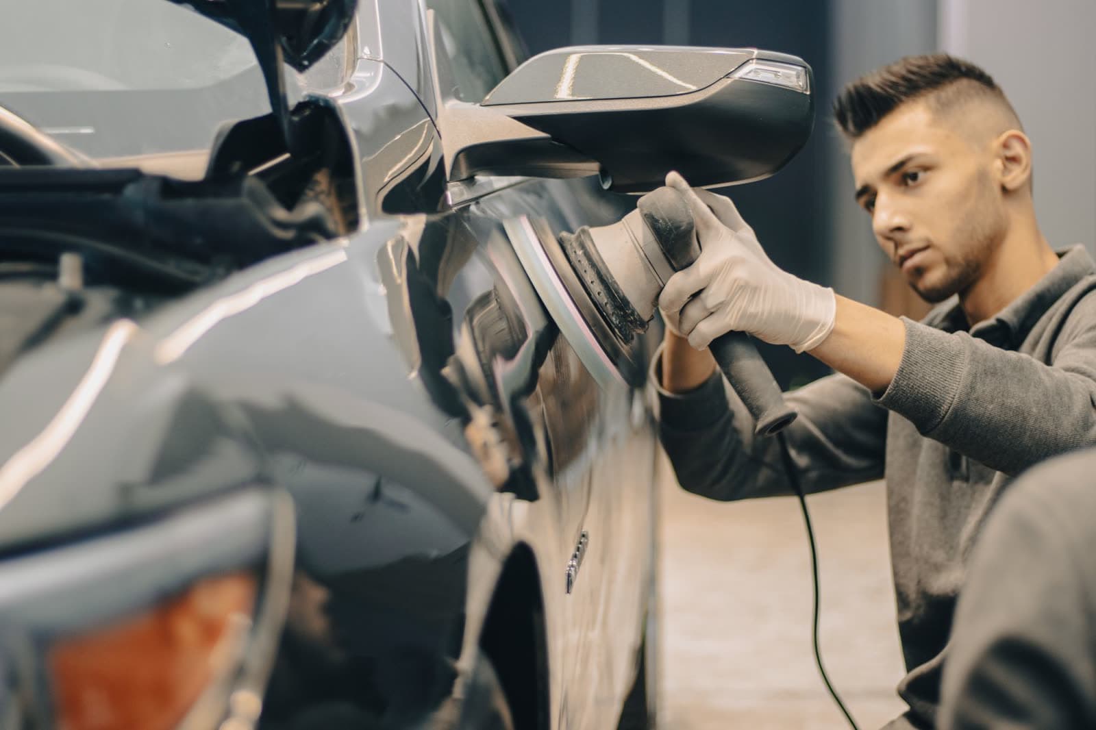 Detailer polishing a car panel